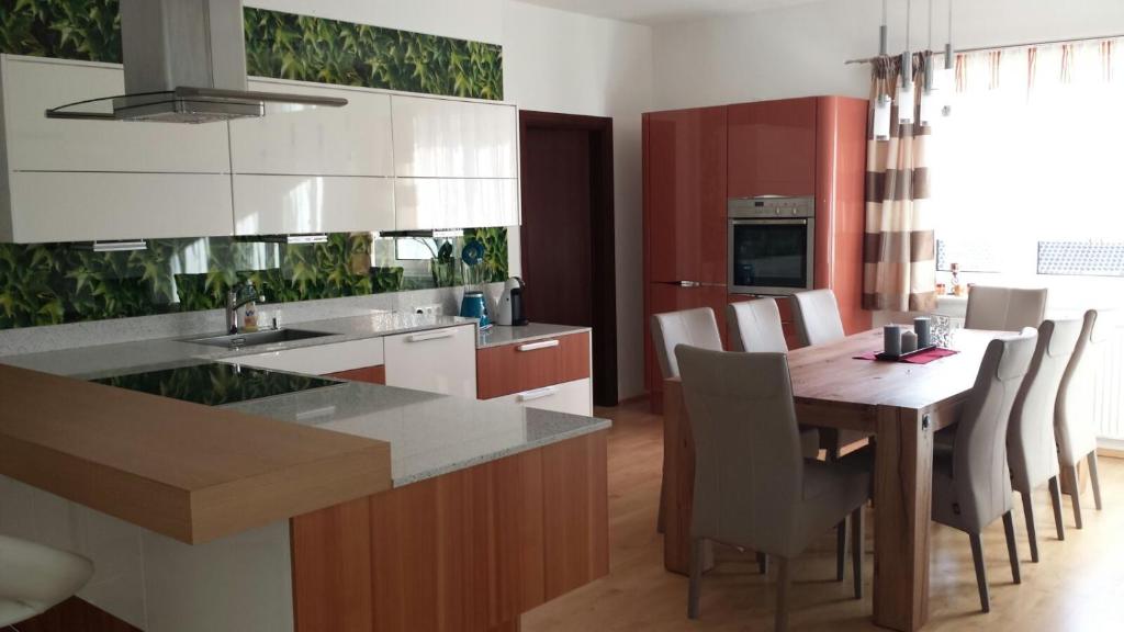 a kitchen with a wooden table and a dining room at Modernes 3-Zimmer-Apartment nahe Graz in Gratkorn