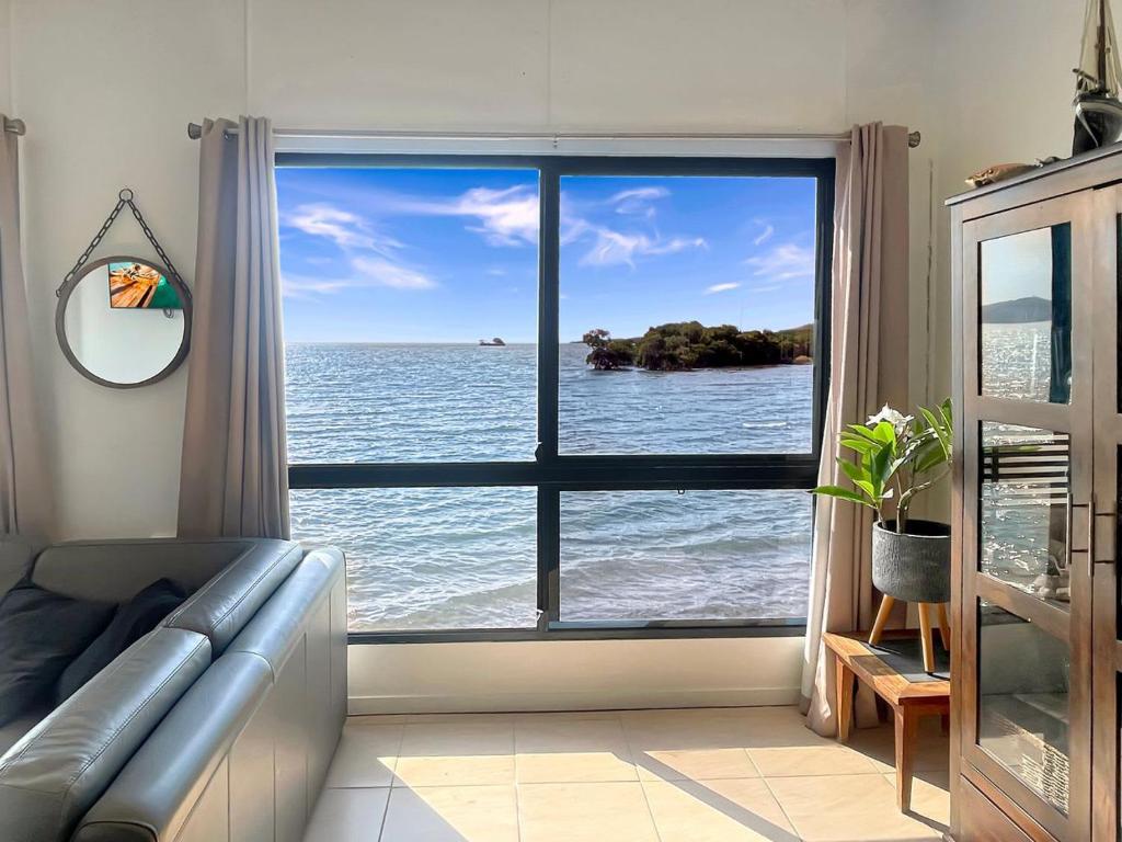 a living room with a window looking out at the ocean at Blue on Cockle in Picnic Bay