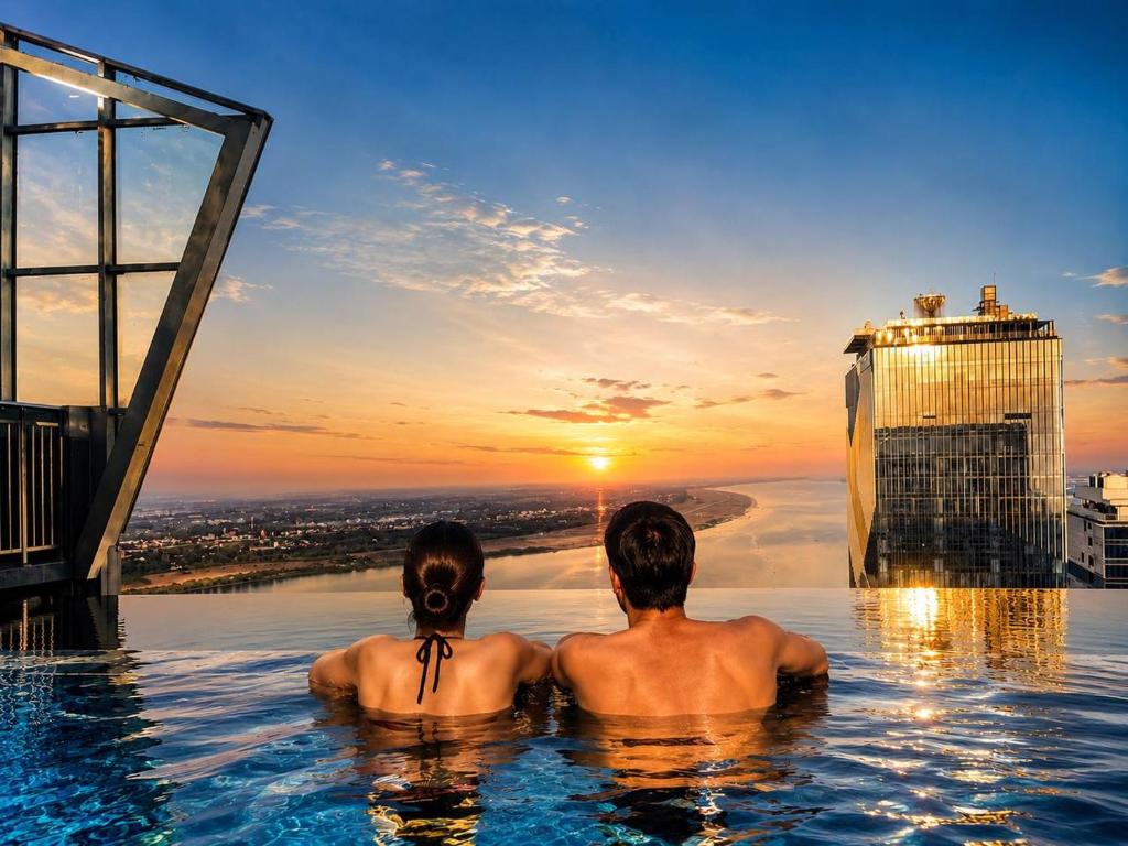 two men sitting in a infinity pool watching the sunset at P Residence Phnom Penh in Phnom Penh