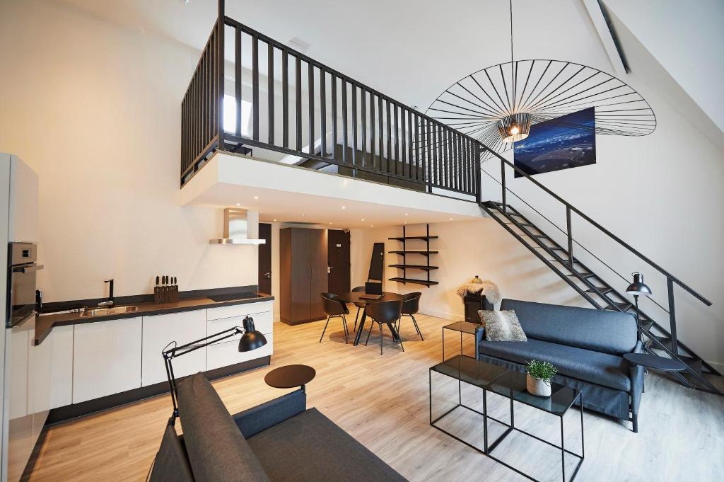 ein Wohnzimmer mit einem blauen Sofa und einer Treppe in der Unterkunft "DE BANK" - Hotel Apartments in Harlingen