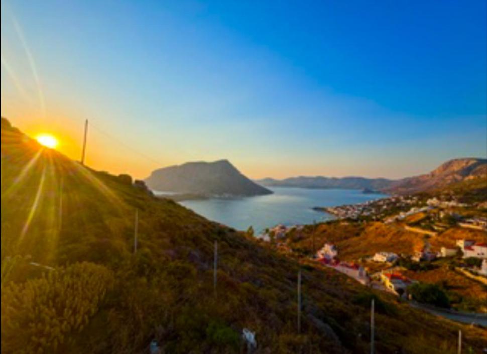 a view of the sun setting over a city and a body of water at Ocean Peak Villa in Kalymnos