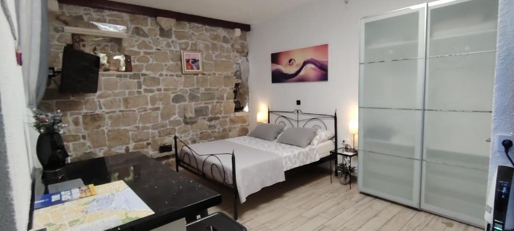 a bedroom with a bed and a stone wall at Apartment Central 1 in Split