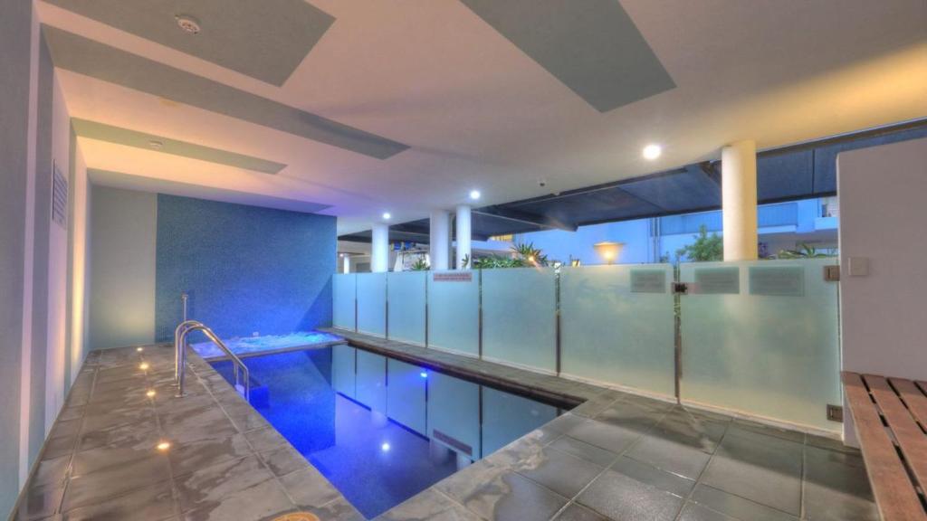 a large swimming pool with blue walls and a swimming poolvisor at Maggies Beachfront Apartment 4 in Horseshoe Bay
