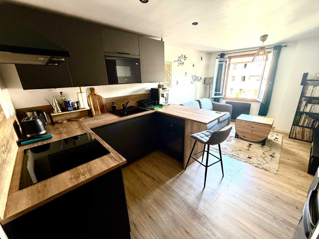 a kitchen with a counter and a table in a room at Appartement cocooning centre ville in Embrun