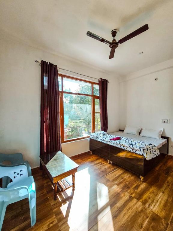a bedroom with a bed and a table and a window at North Sky Stays Bir in Bīr