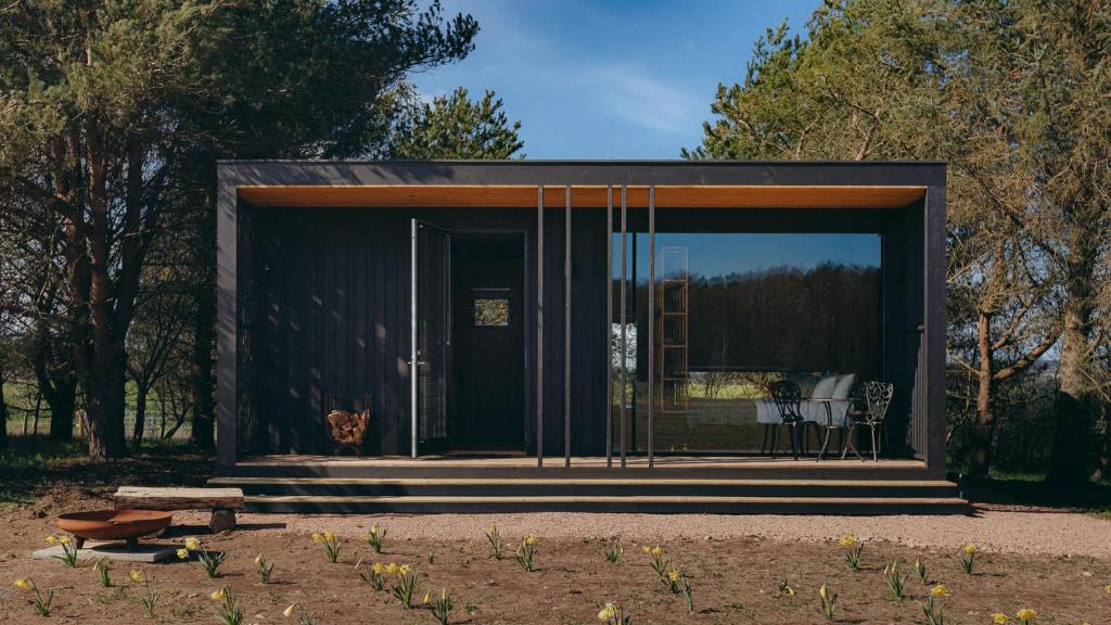 a small black house with a large glass door at Owl in St. Andrews