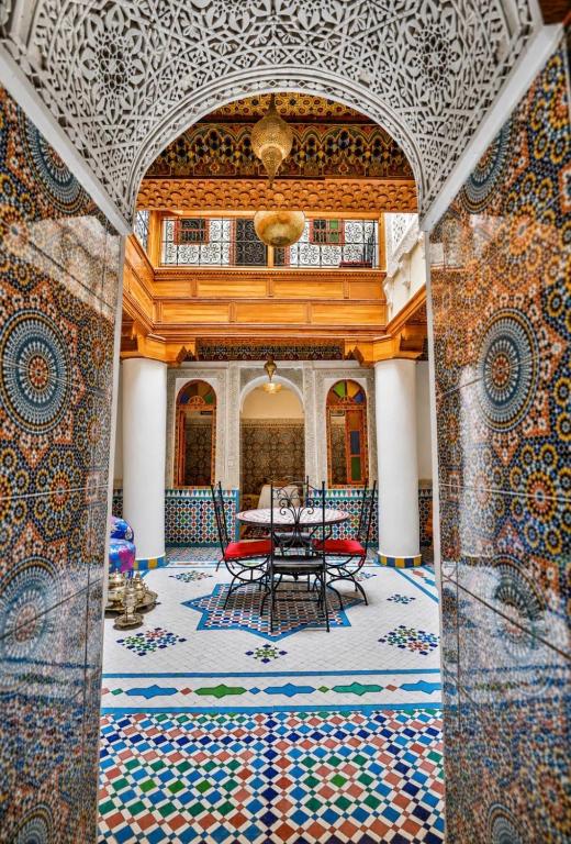 a dining room with a table and a mosaic floor at Riad Fes Layan in Fez