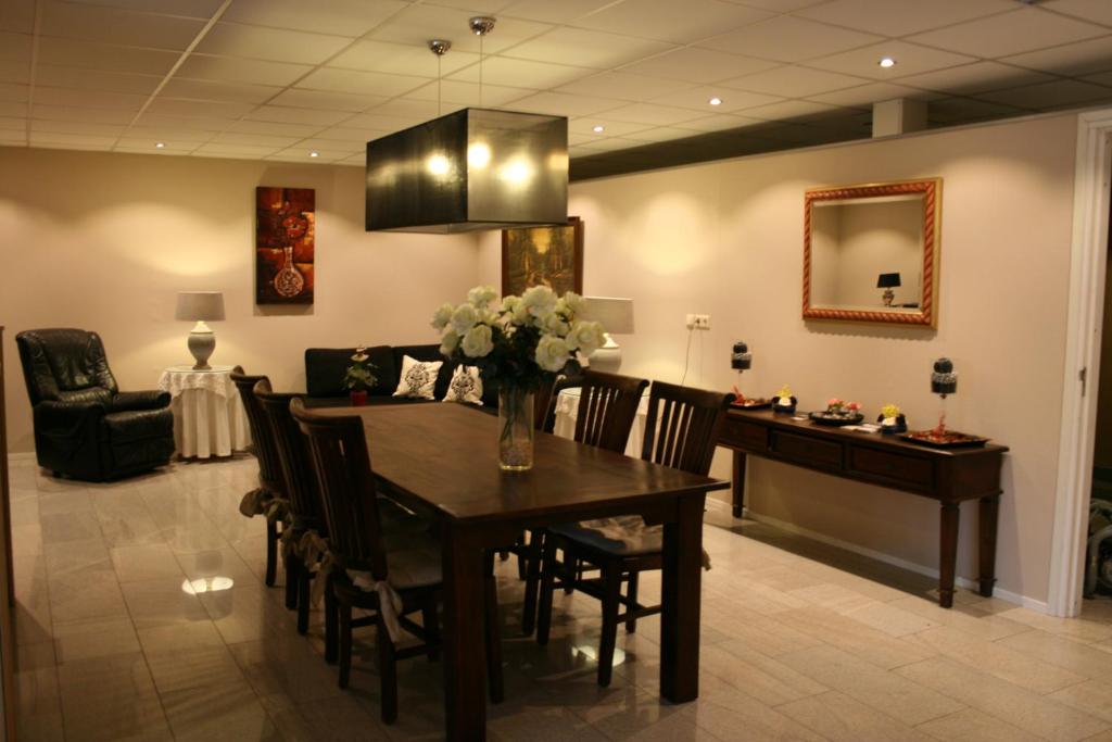 a dining room and living room with a table and chairs at B&B De Tobbedanser Harlingen in Harlingen