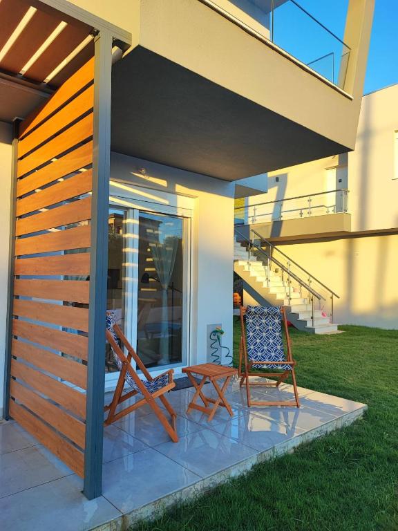 two chairs and a table on a patio under a house at Blue view in Skala Rachoniou