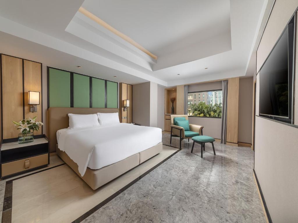 a hotel room with a bed and a television at Samala Suites Bangkok Sukhumvit 19 by Kingston Hotels in Bangkok