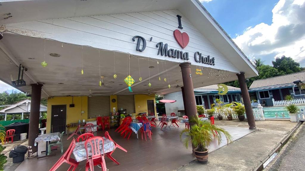 a restaurant with red tables and chairs in front of it at Hotel O D Mama Chalet in Jeniang