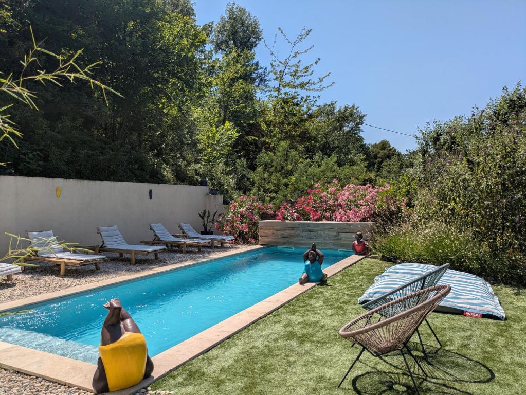 a backyard with a swimming pool with two children playing in the grass at Bulles d'Olive Provence avec piscine - Jacuzzi en option in Nyons