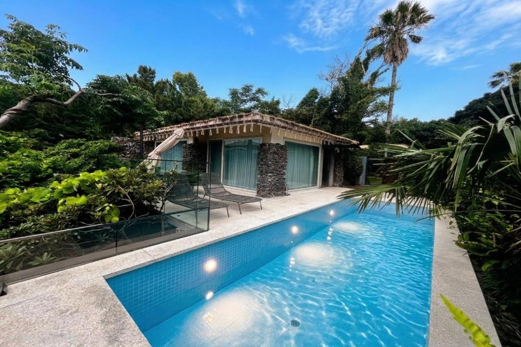 a swimming pool in front of a house at The Seaes Hotel & Resort in Seogwipo