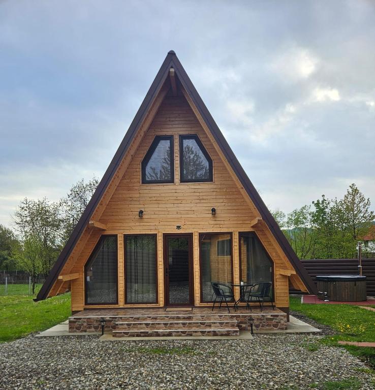 a cabin with a gambrel roof with windows at Plai cu dor - Brebu in Brebu Mînăstirei