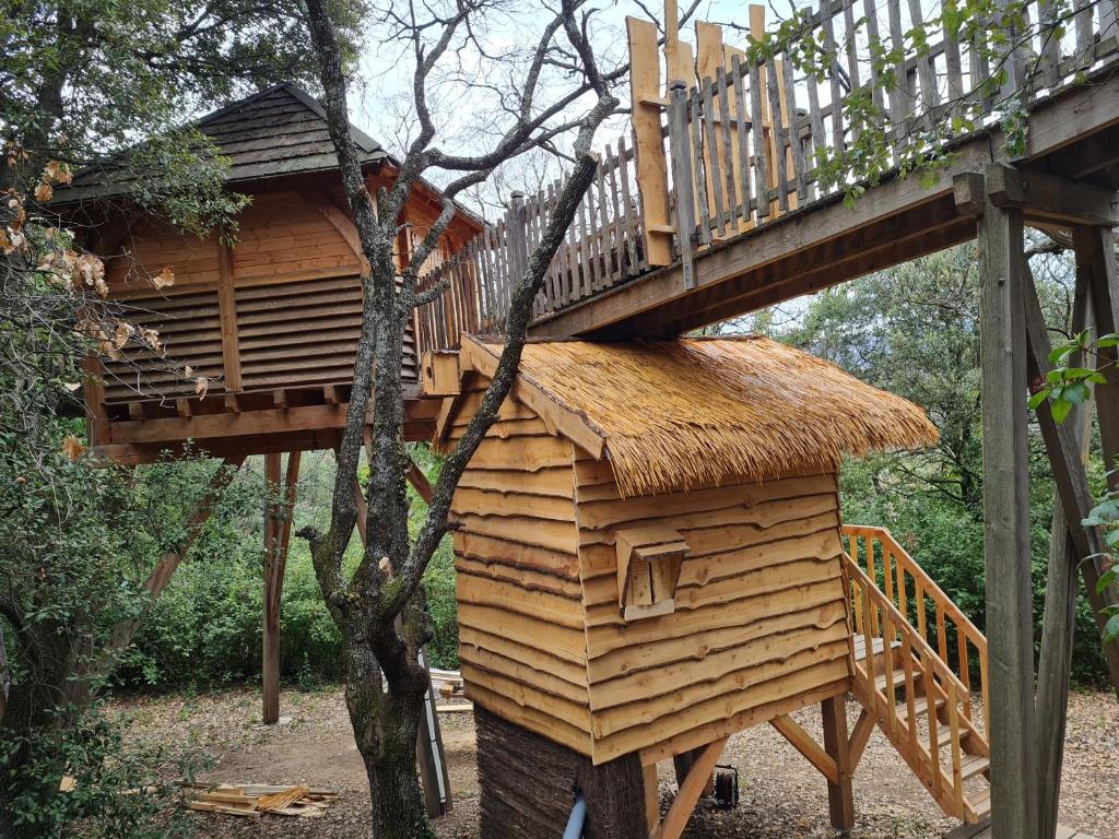 a tree house with a deck on top of it at L'écureuil perché in Apt