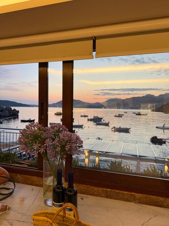 a window with a view of a harbor with boats at Villa Brodetto, Sveti Stefan in Pržno