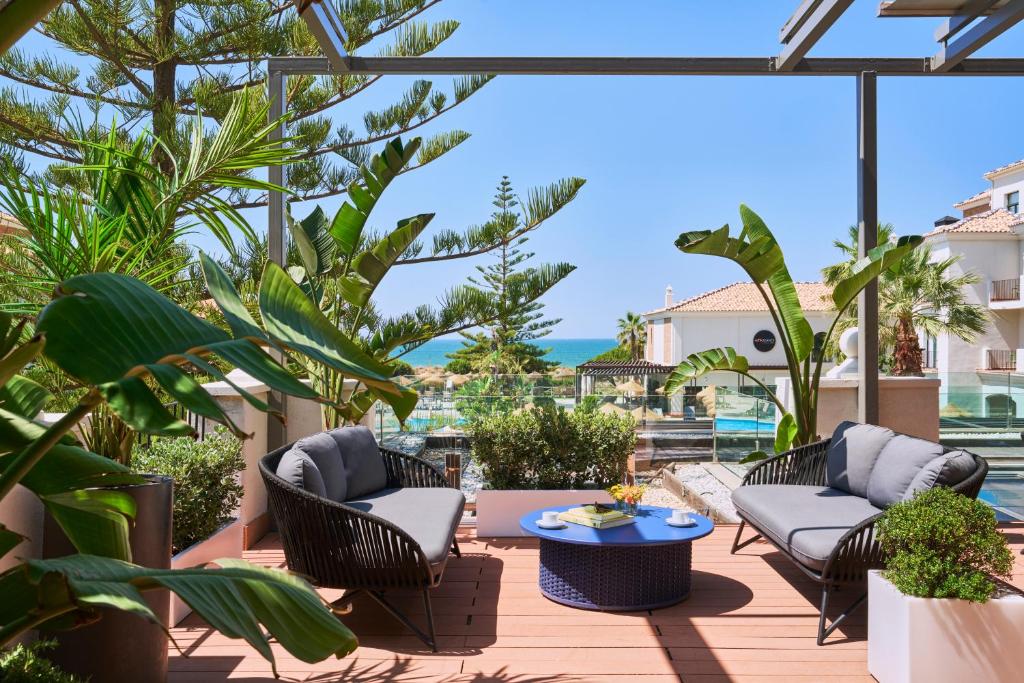 a patio with chairs and a table and plants at Barceló Punta Umbría Mar in Punta Umbría