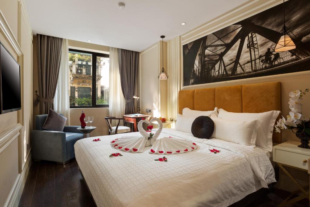 a hotel room with a bed with flowers on it at Hanoi La Storia Hotel in Hanoi
