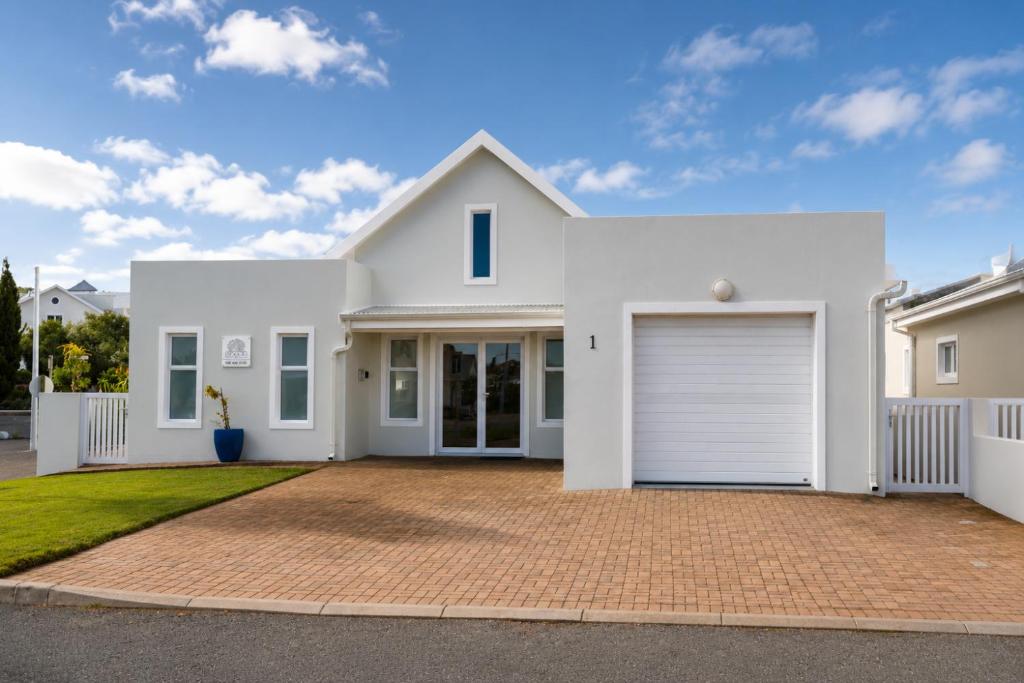 a white house with a garage at Die Koraalbos in Stilbaai-Oos