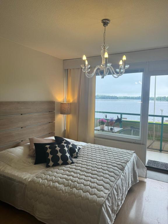a bedroom with a large bed and a large window at Hotelli Terme 111 in Kilvakkala