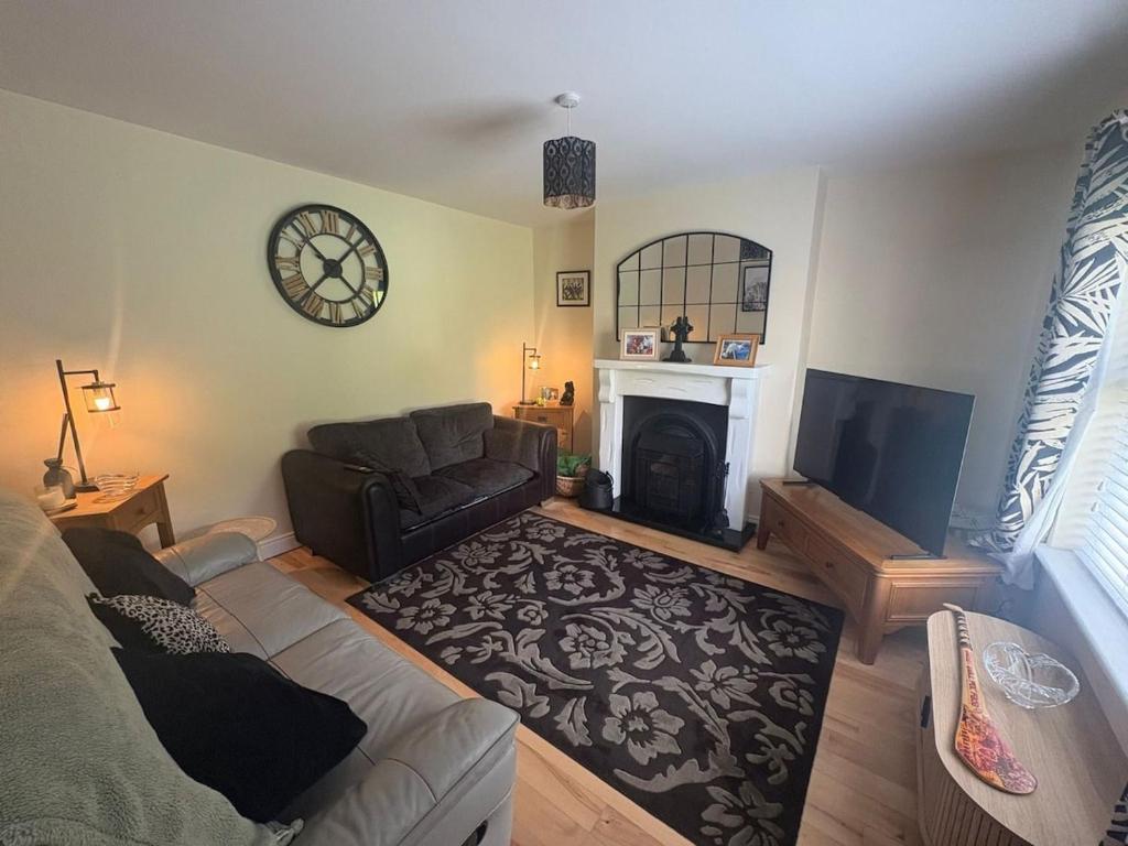 a living room with a couch and a fireplace at The Cloverhill House in Mullaghbane