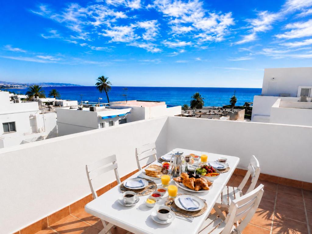a table with food on a balcony with a view of the ocean at Velez Nazari Cambriles in Lújar
