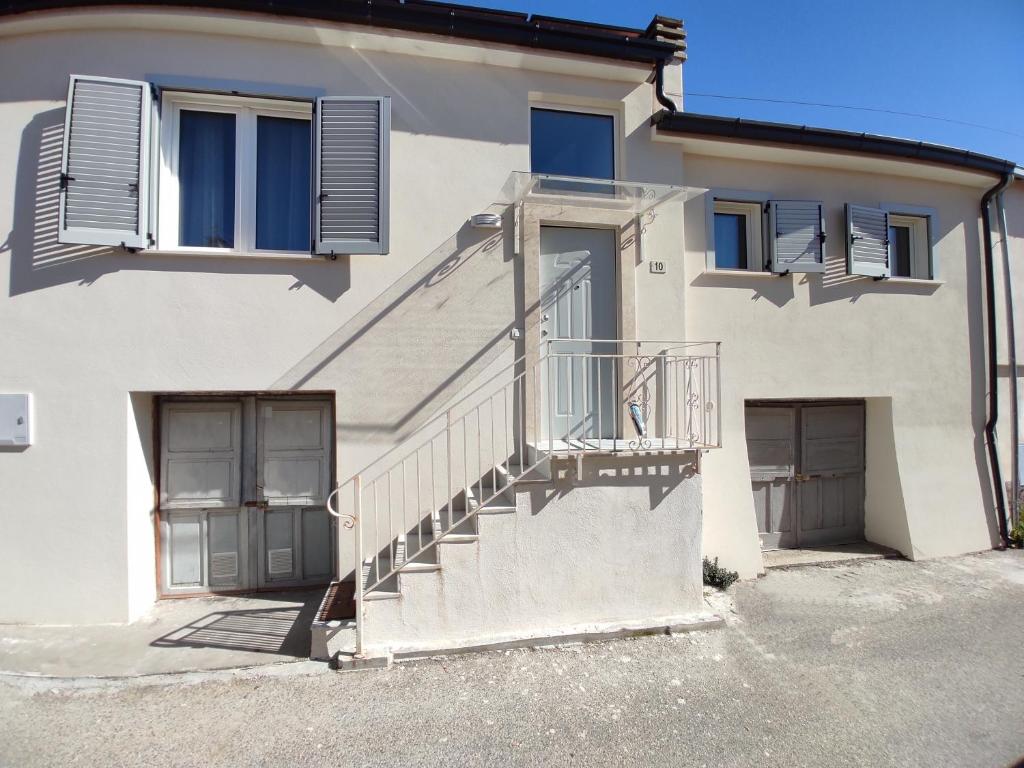 a white house with a staircase and windows at Tra i Parchi in Pescina