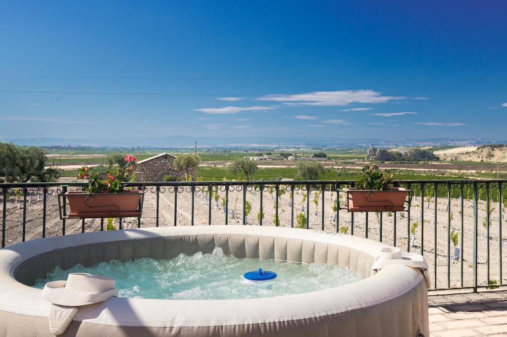 a hot tub sitting on top of a balcony at Oasi Orange Villa with Jacuzzi in Paterno