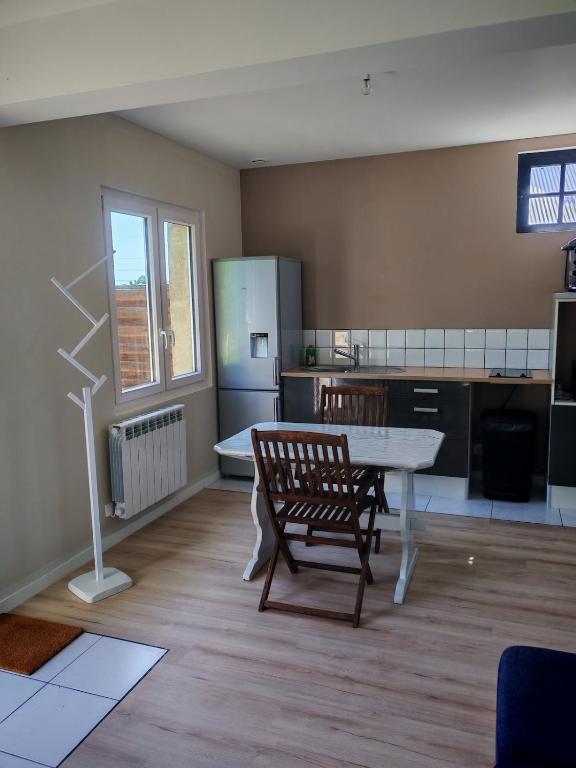 a kitchen with a table and chairs in a room at Studio indépendant tout équipé proche circuit des 24 Heures in Teloché