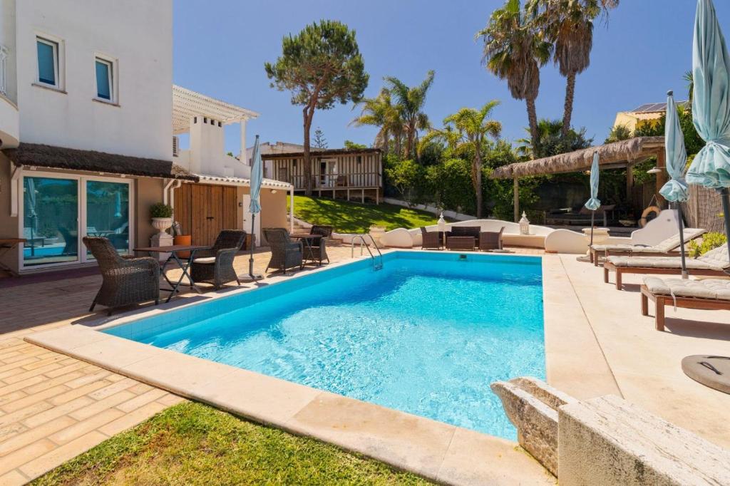 a swimming pool in the backyard of a house at Kochab Comporta in Comporta