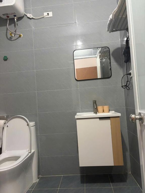 a bathroom with a toilet and a sink and a mirror at Hotel Bích Lam in Phong Xá