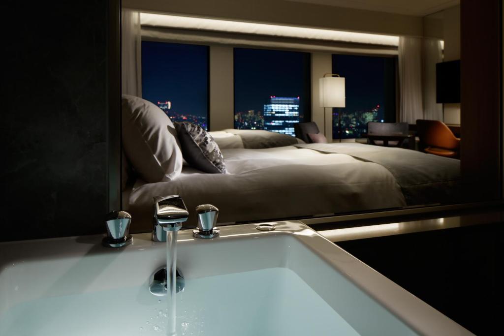 a bathroom with a large bed and a bath tub at Keio Plaza Hotel Tokyo in Tokyo