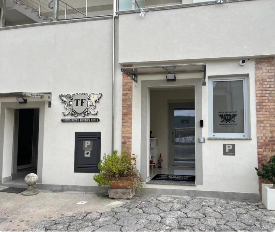 a white building with a sign on the side of it at Terraforte Luxury Suite in Fisciano