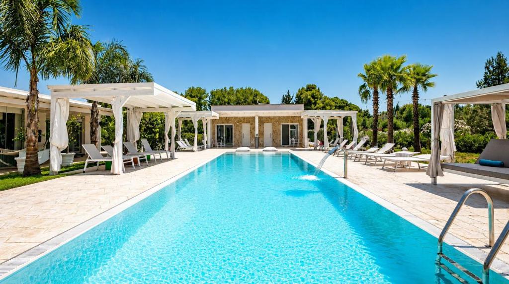 a swimming pool with chairs and a villa at Luxury Home & Pool by Symphonya Luxury Holiday Rentals in Lequile