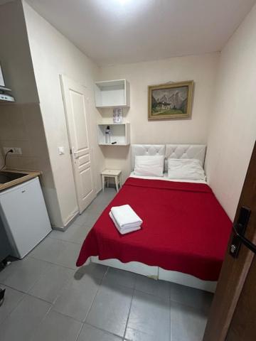 a bedroom with a red bed with a red blanket at myappart - La Garenne in La Garenne-Colombes