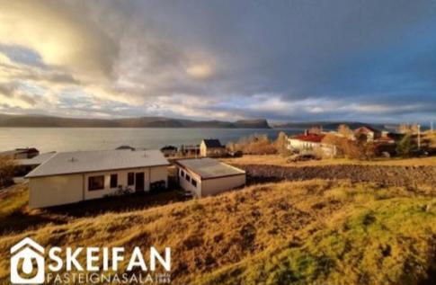 a house on the shore of a body of water at Great place to see the solar eclipse! in Patreksfjörður