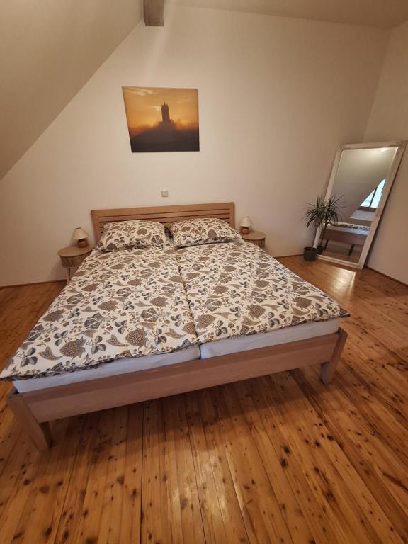 a bed in a bedroom with a wooden floor at PoBytPodivín in Podivín