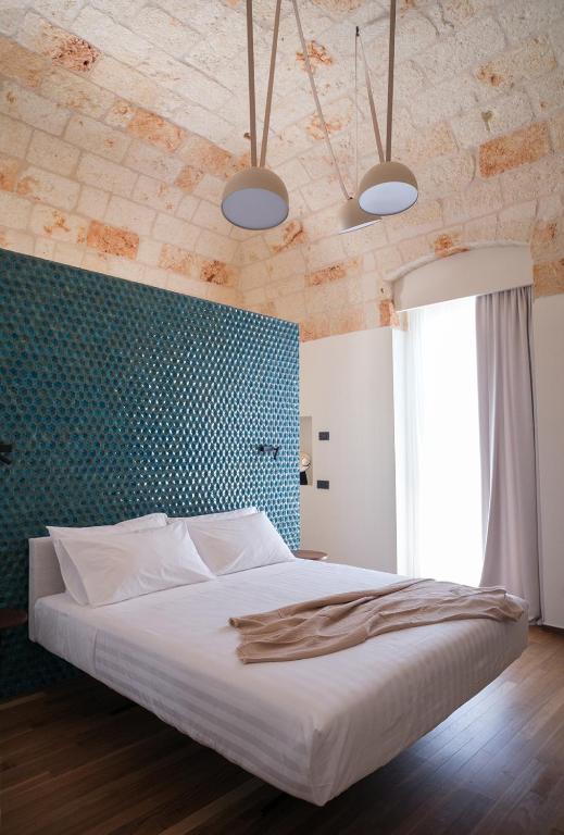 a bedroom with a large bed with a blue wall at Benedamò Home Inside in Polignano a Mare