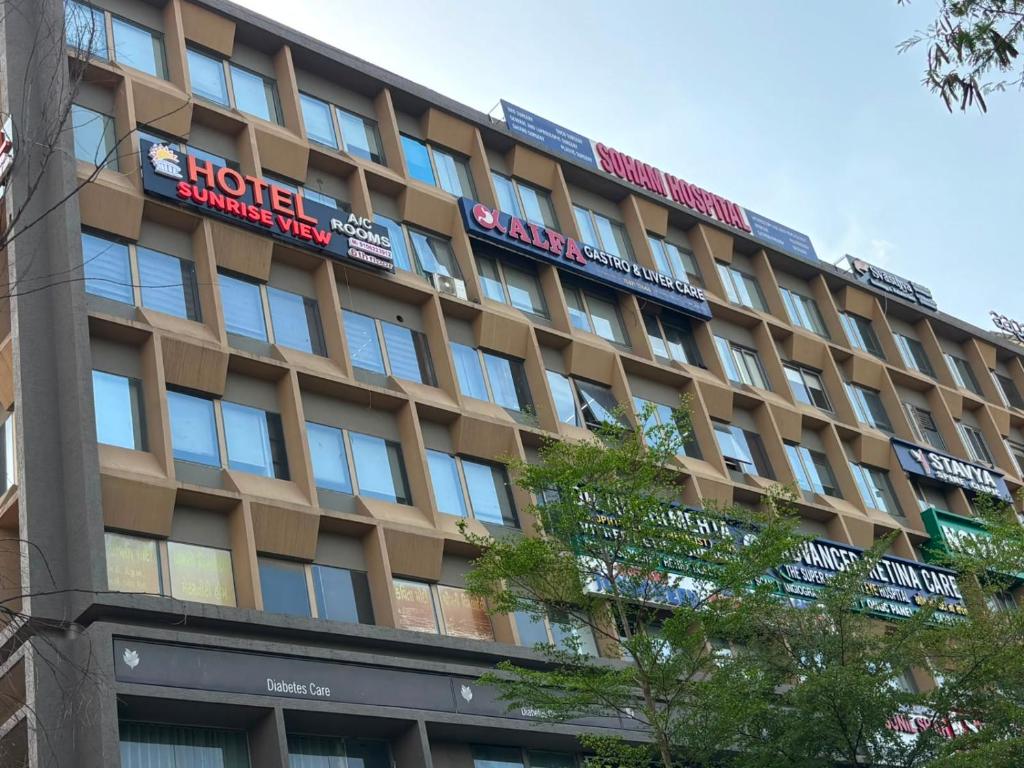 a large building with a sign on top of it at Hotel Sunrise View in Ahmedabad