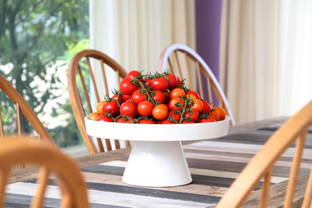 un tazón de tomates sentado sobre una mesa en De Tomaat, en Aarle-Rixtel
