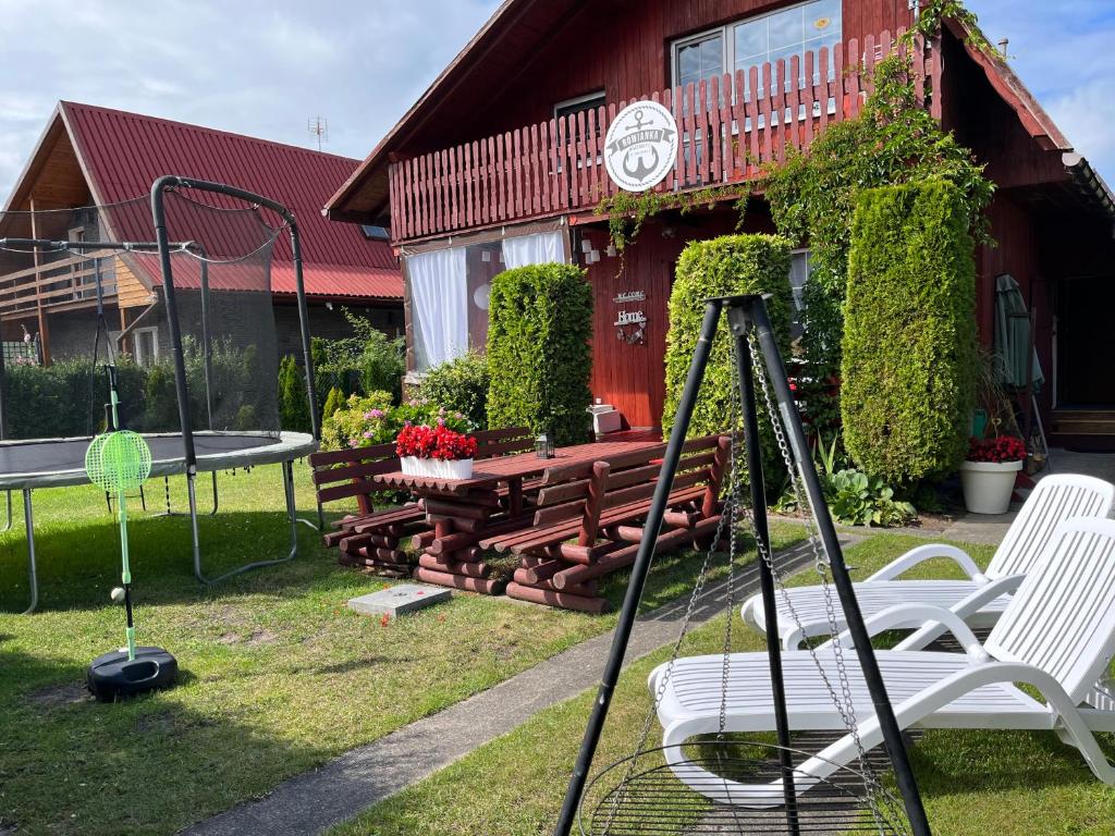 Eine Tischtennisplatte und Stühle vor einem Haus in der Unterkunft Rowianka in Rowy