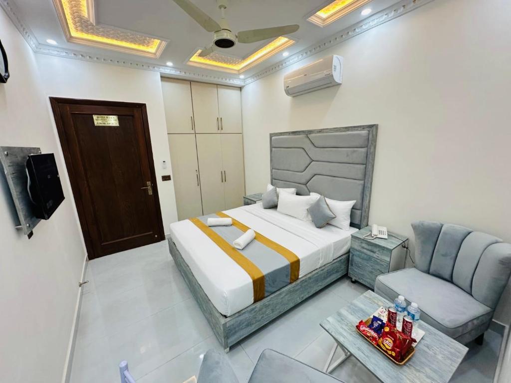 a bedroom with a bed and a couch and a chair at Go 001 Hotel Lahore in Lahore