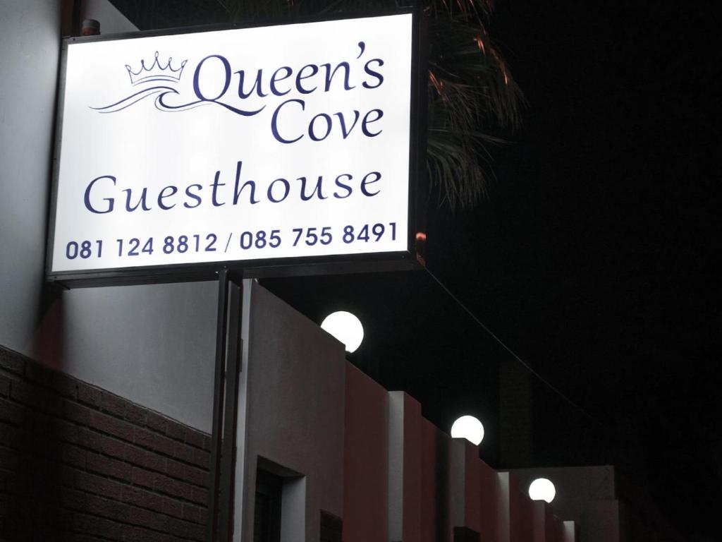 a sign for a queens cove guest house on a building at Queens Cove in Lüderitz
