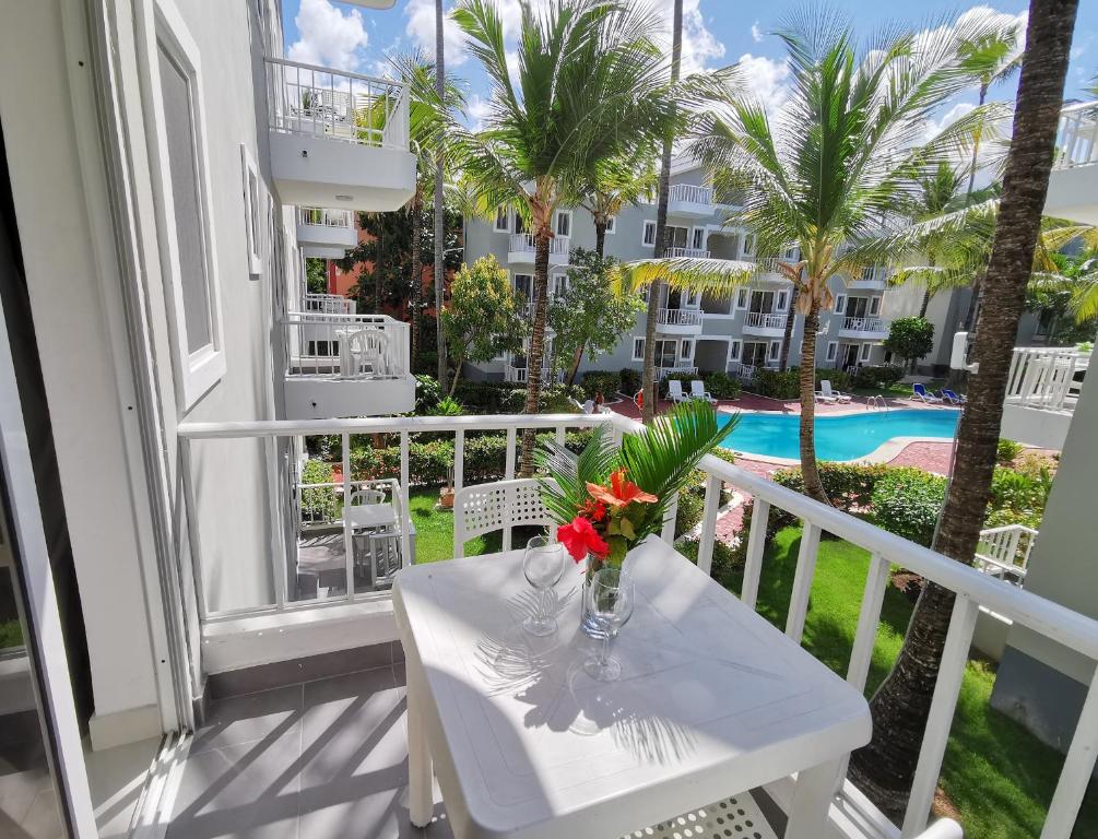 a table with a vase of flowers on a balcony at Seaside Oasis at Playa Los Coralles in Punta Cana