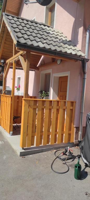 a house with a wooden porch with a roof at Studio Babji zob in Bohinjska Bela