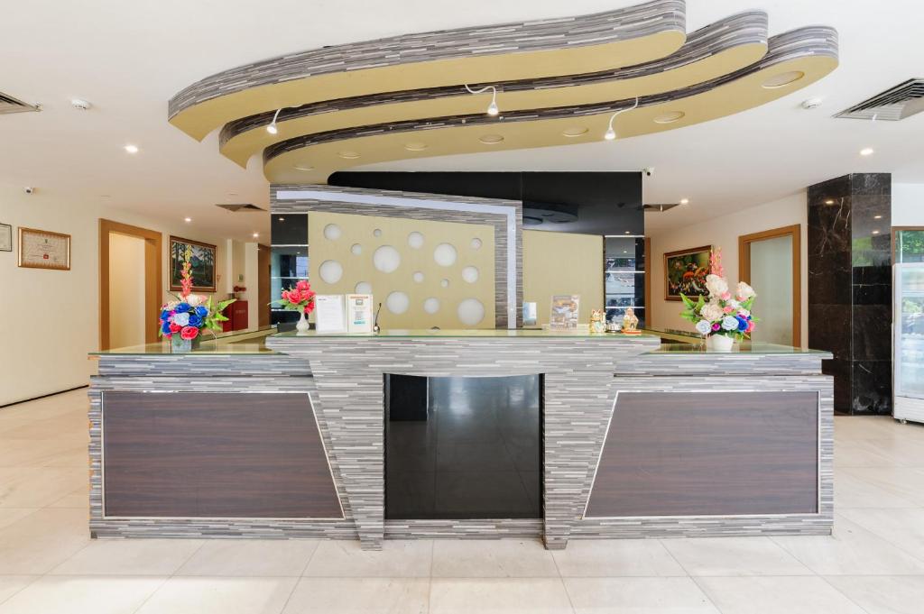 a lobby with a bar in a building at SANS Vibes d Grande Hotel Batam in Nagoya
