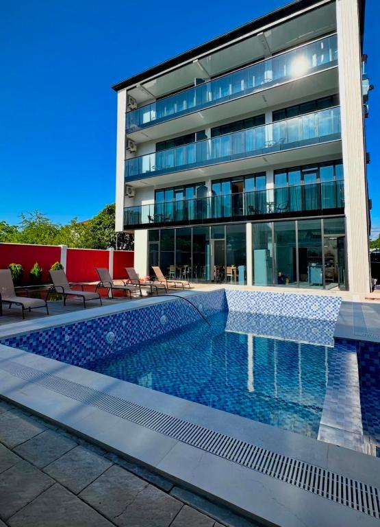 a building with a swimming pool in front of a building at Hotel Nena in Kobuleti