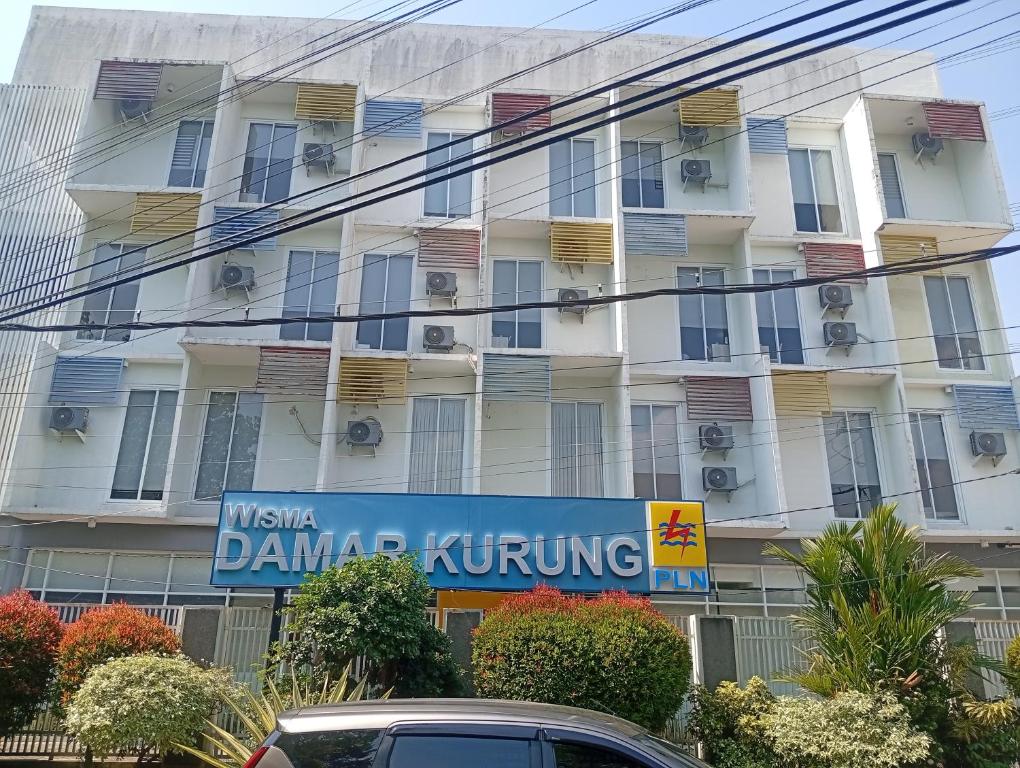 a building with a sign in front of it at Townhouse Oak Hotel Damar Kurung in Gresik