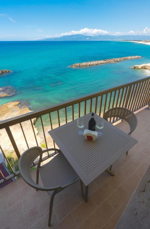 a table and chairs on a balcony overlooking the ocean at Casa Alexandr Azzurra in Pizzo