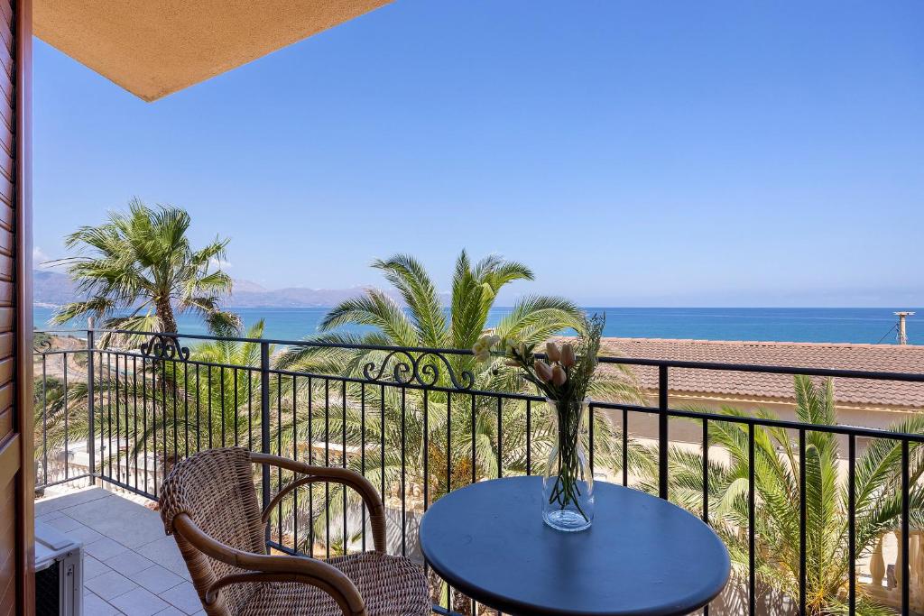 a table with a vase of flowers on a balcony at Casa Onda Azzurra in Balestrate